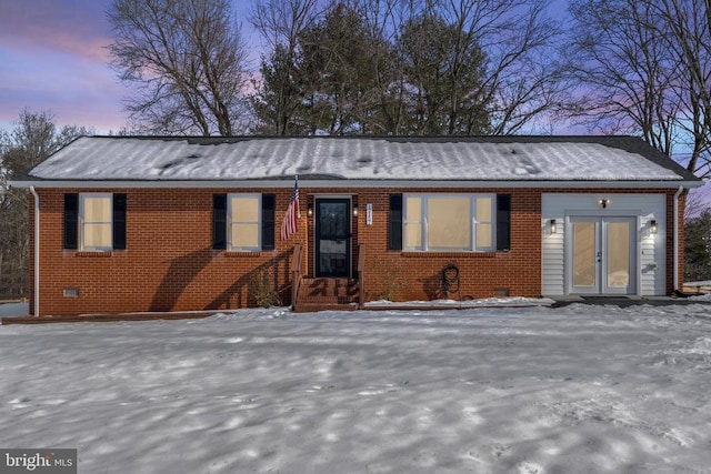 view of front of home featuring brick siding and crawl space