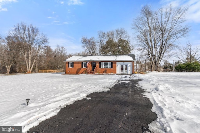 snow covered rear of property featuring french doors