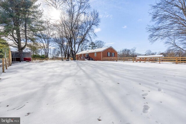 yard layered in snow with fence and an outdoor structure