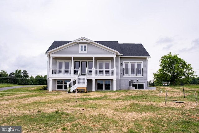 back of house with stairs and a yard