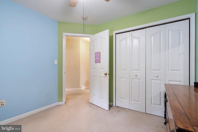 unfurnished bedroom featuring light colored carpet, a closet, and ceiling fan