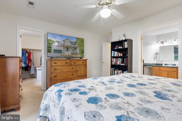 carpeted bedroom featuring a spacious closet, connected bathroom, ceiling fan, and a closet