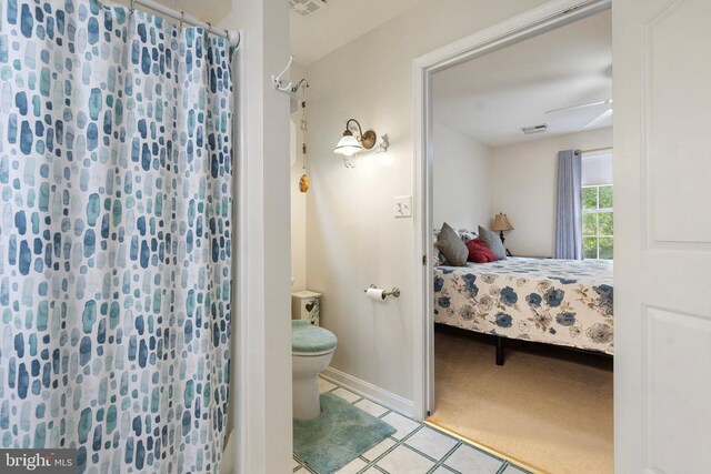 bathroom with walk in shower, ceiling fan, tile patterned floors, and toilet