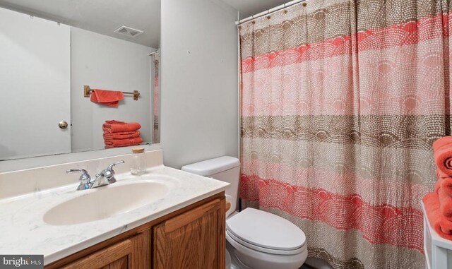 bathroom with vanity, walk in shower, and toilet