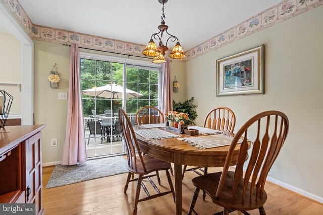 dining area with an inviting chandelier and light hardwood / wood-style floors