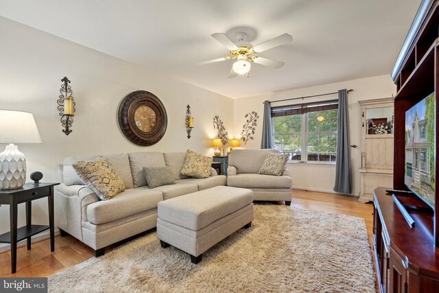 living room featuring ceiling fan and light wood-type flooring