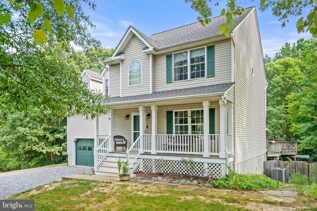 view of front of property with central AC, a garage, and covered porch