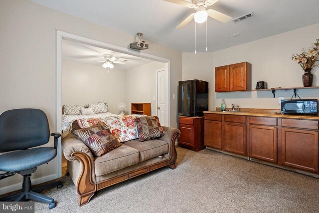 carpeted living room featuring ceiling fan and sink