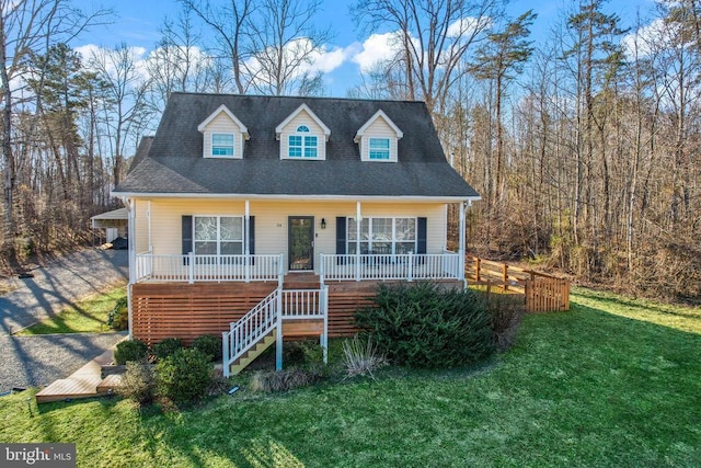 view of front of house with covered porch, a front lawn, stairway, and a shingled roof