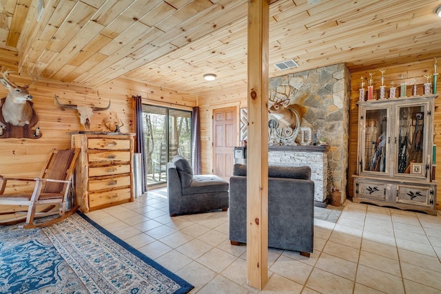 interior space featuring wood ceiling, tile patterned floors, a fireplace, and wood walls