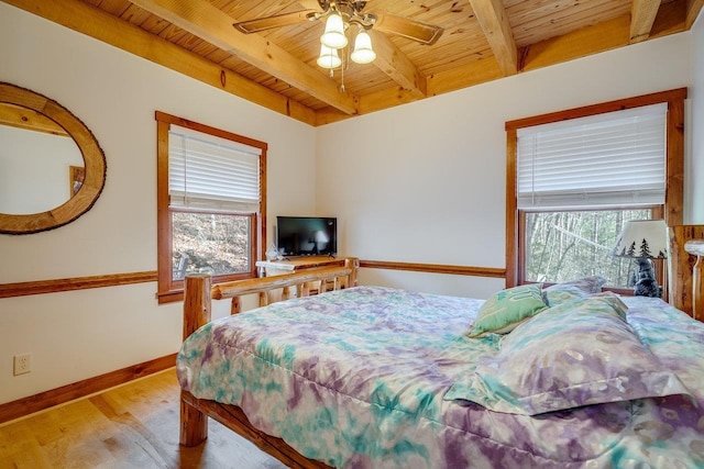 bedroom with beamed ceiling, wooden ceiling, ceiling fan, and light hardwood / wood-style flooring