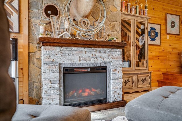 tiled living room featuring a fireplace and wooden walls