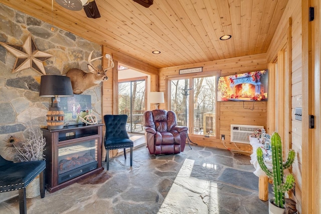 sitting room with an AC wall unit, wood ceiling, and wood walls