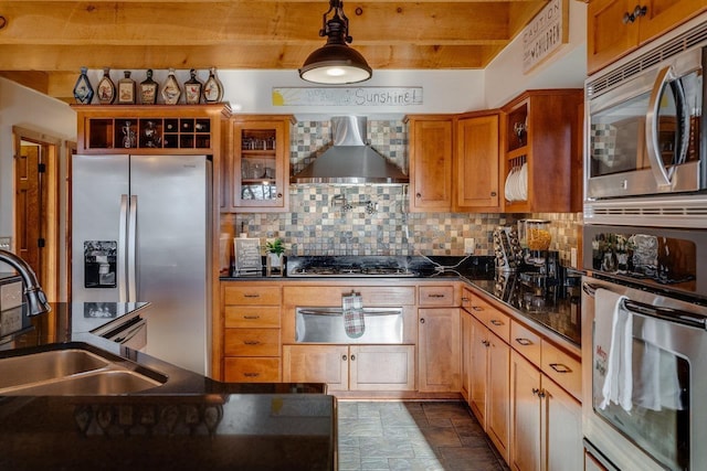 kitchen with wall chimney exhaust hood, sink, tasteful backsplash, pendant lighting, and stainless steel appliances