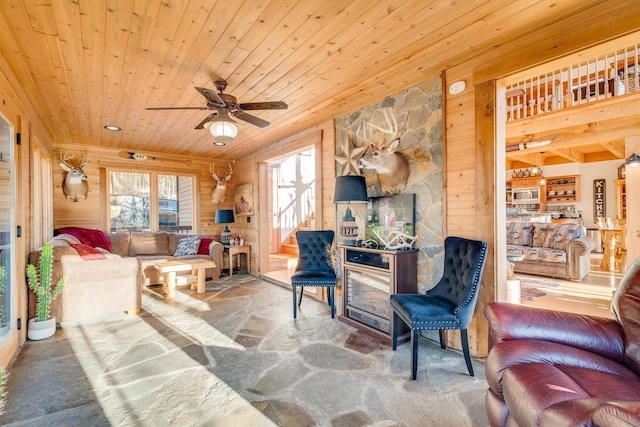 living room featuring wooden walls, wooden ceiling, and ceiling fan