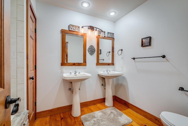 bathroom featuring double sink, toilet, and hardwood / wood-style floors