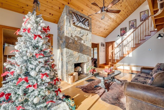 living room with wood ceiling, high vaulted ceiling, ceiling fan, a fireplace, and hardwood / wood-style floors