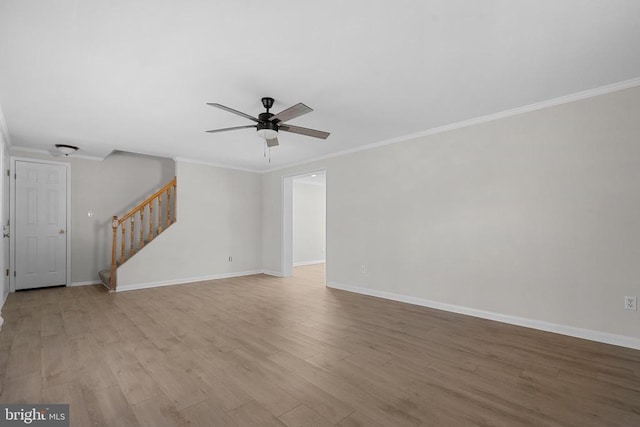 unfurnished living room with ornamental molding, stairs, baseboards, and wood finished floors