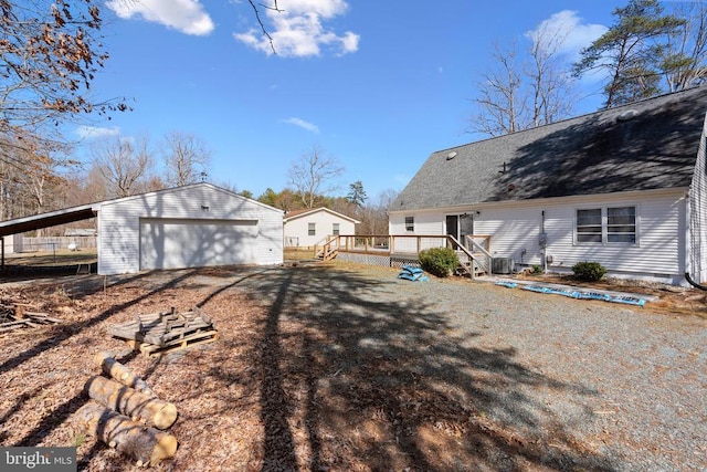 exterior space featuring a garage, an outbuilding, and a deck