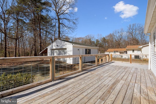 wooden terrace with an outbuilding and a detached garage