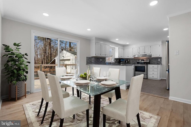 dining area with recessed lighting, light wood-style flooring, and crown molding