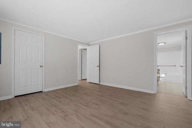 unfurnished bedroom with baseboards, light wood-style floors, ornamental molding, and ensuite bathroom