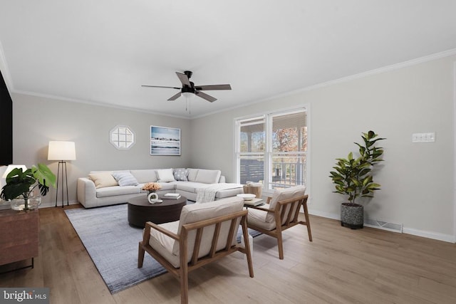 living area with ceiling fan, light wood-type flooring, baseboards, and ornamental molding