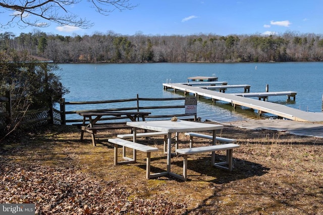 view of dock featuring a water view and a wooded view