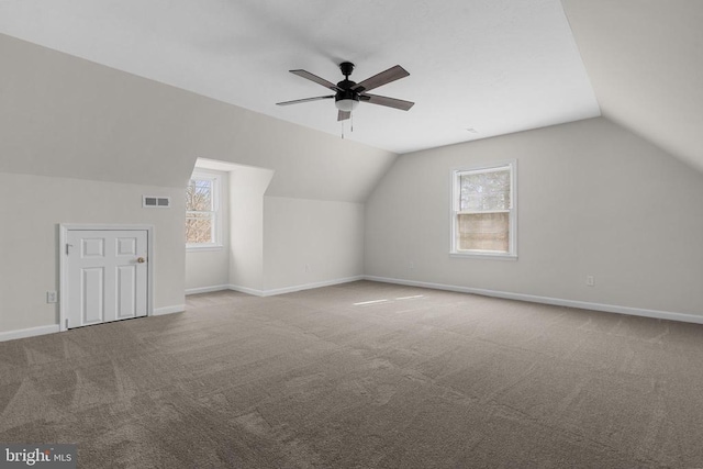 additional living space with visible vents, carpet flooring, lofted ceiling, and baseboards