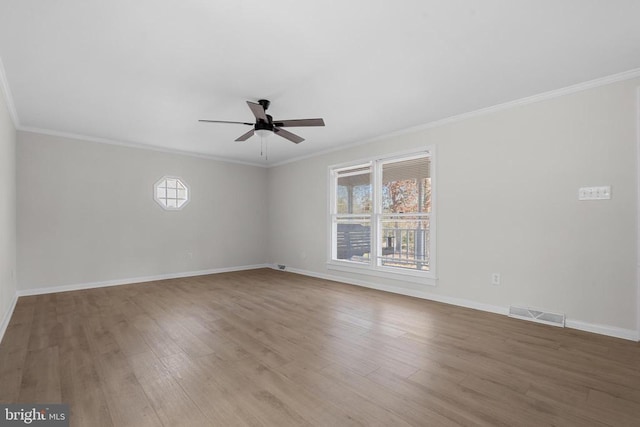 unfurnished room with visible vents, wood finished floors, crown molding, baseboards, and ceiling fan