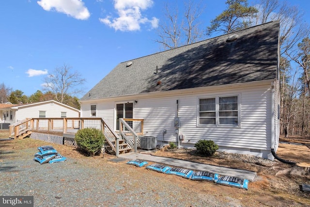 back of property featuring a deck, cooling unit, and roof with shingles