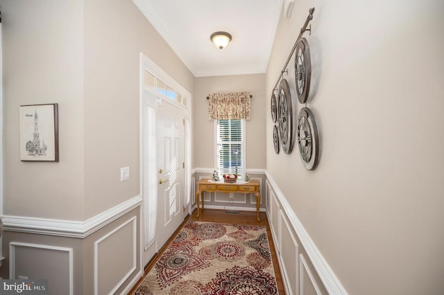 doorway to outside featuring crown molding, a decorative wall, and a wainscoted wall