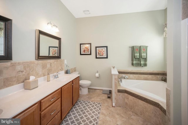 full bathroom featuring tile patterned flooring, baseboards, toilet, a bath, and vanity