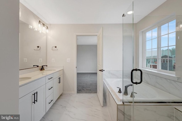 bathroom with double vanity, baseboards, a garden tub, marble finish floor, and a sink