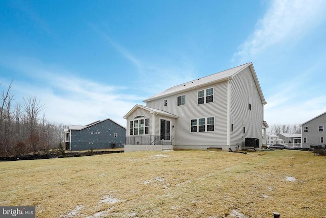 back of property with central AC and a yard