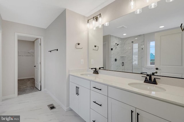 bathroom featuring visible vents, marble finish floor, a sink, and a walk in closet