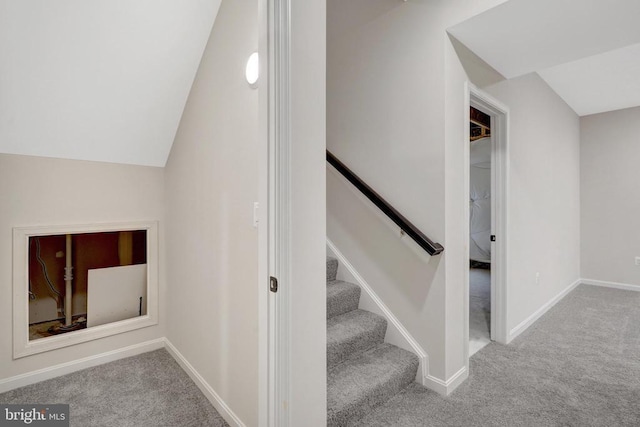 stairs featuring lofted ceiling, carpet, and baseboards