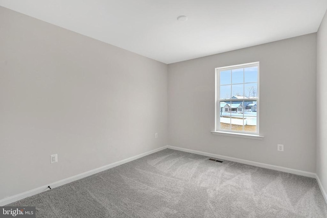 carpeted empty room featuring visible vents and baseboards