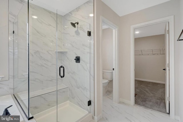 bathroom with marble finish floor, a walk in closet, a marble finish shower, and baseboards