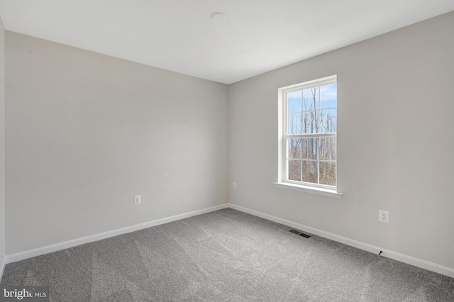 unfurnished room with carpet floors, baseboards, and visible vents