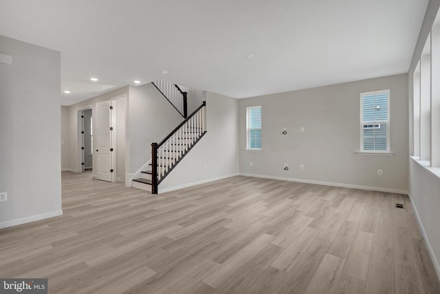 interior space featuring recessed lighting, visible vents, baseboards, stairs, and light wood-style floors