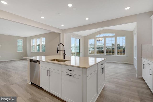 kitchen with a sink, open floor plan, dishwasher, and light countertops