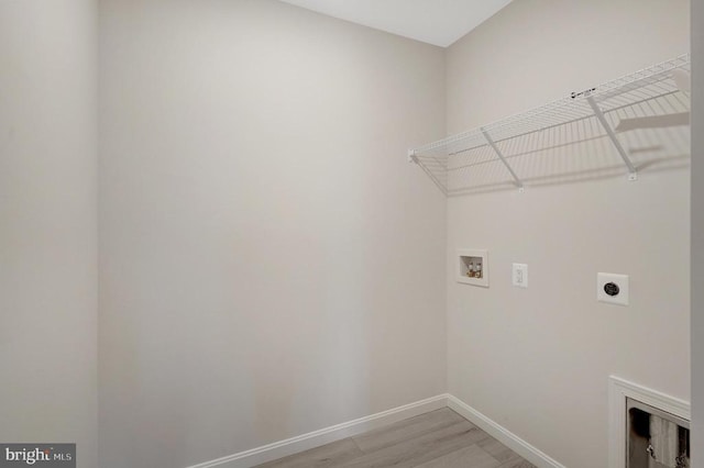 laundry room featuring hookup for a washing machine, hookup for an electric dryer, laundry area, baseboards, and light wood finished floors