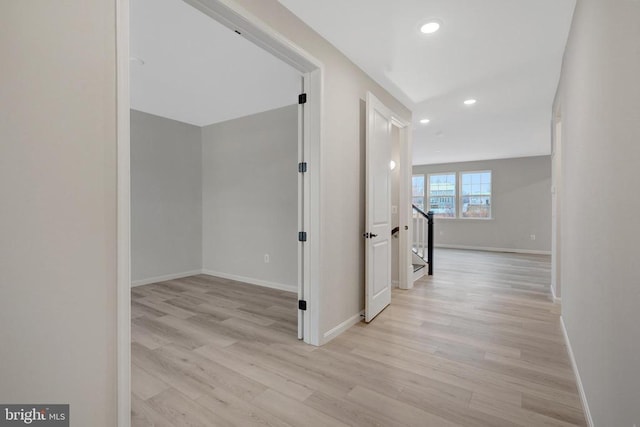 corridor with stairway, recessed lighting, light wood-style flooring, and baseboards