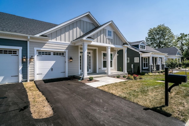 view of front of home with a garage, a front lawn, and a porch