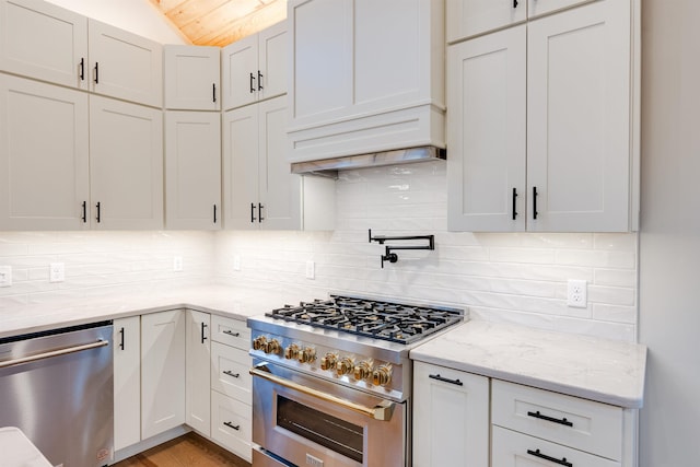 kitchen with appliances with stainless steel finishes, light stone countertops, decorative backsplash, and white cabinets