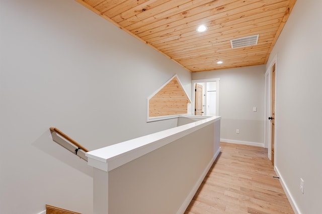 hall featuring light hardwood / wood-style floors and wooden ceiling