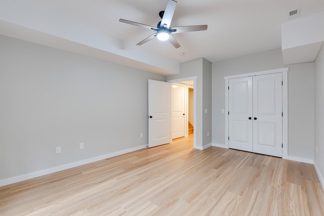 unfurnished bedroom featuring light hardwood / wood-style flooring, a closet, and ceiling fan