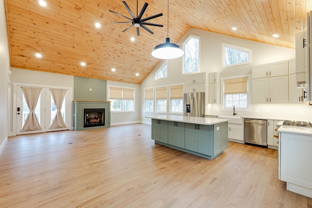 kitchen featuring stainless steel appliances, white cabinetry, a center island, and pendant lighting