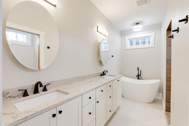 bathroom featuring vanity, a bath, tile patterned flooring, and a wealth of natural light